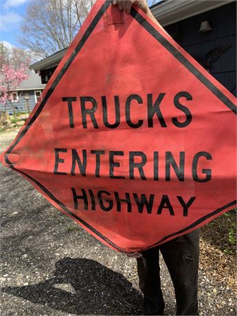 Large Orange Construction Sign That Says Trucks Entering Highway