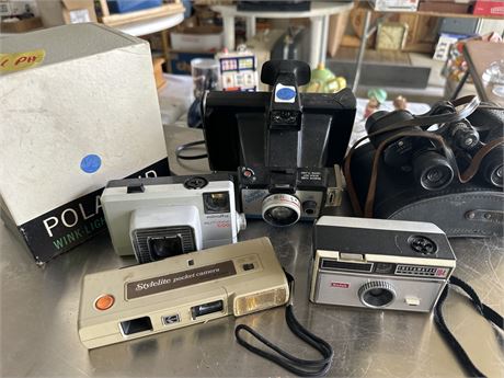 A lot of vintage cameras and binoculars