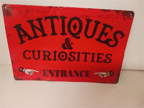 Antiques & Curiosities Metal Sign. Sign Is Damaged. Has Dent & Crease In It